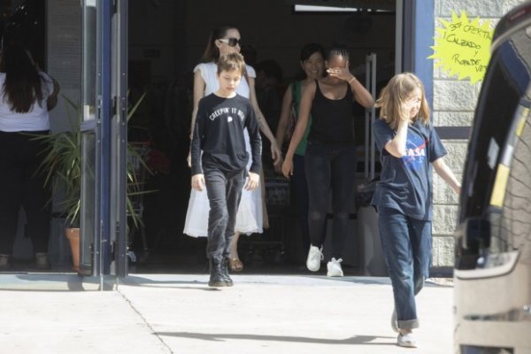 Счастливая Анджелина Джоли в белом  платье, гуляет с детьми по магазинам