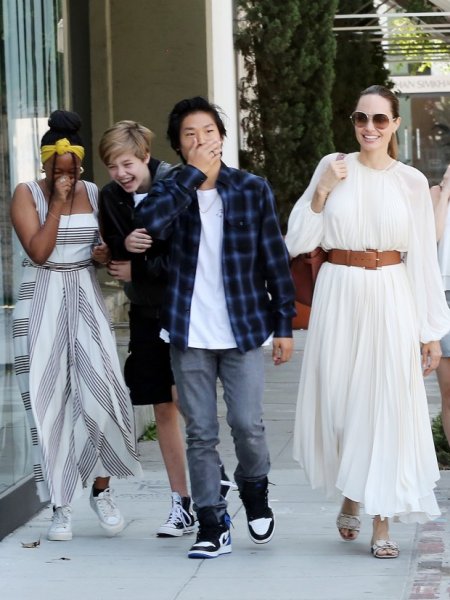 Счастливая Анджелина Джоли в белом  платье, гуляет с детьми по магазинам