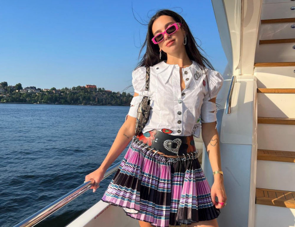 Dua Lipa in a Barbie outfit rests on the sea